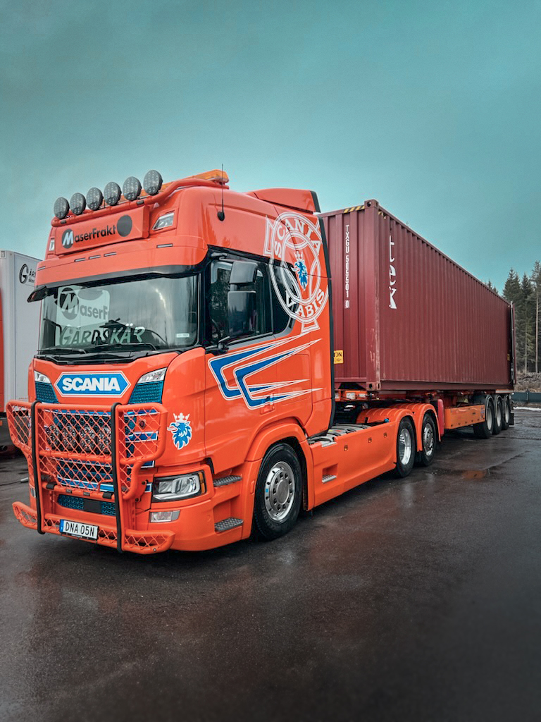Orange MaserFrakt lastbil med sjöcontainer